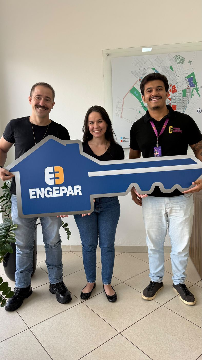 Clientes e corretor segurando uma chave gigante da Engepar