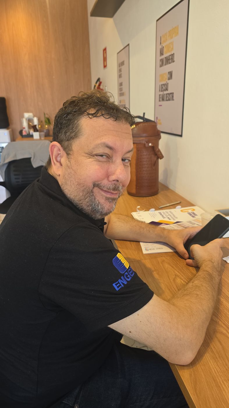 Integrante do time sorrindo na mesa de trabalho